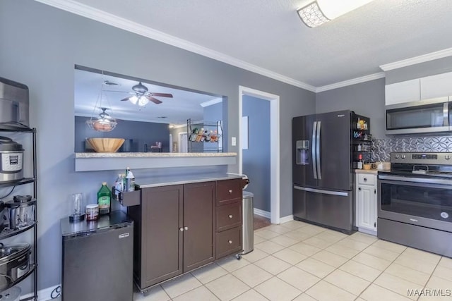 kitchen featuring decorative backsplash, white cabinetry, stainless steel appliances, and crown molding