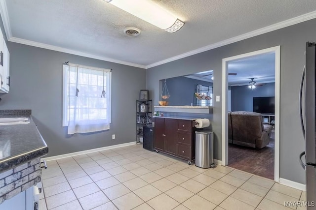 kitchen with light tile patterned floors, visible vents, and ornamental molding