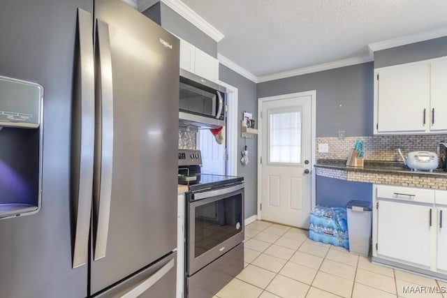 kitchen with crown molding, light tile patterned floors, decorative backsplash, white cabinets, and stainless steel appliances