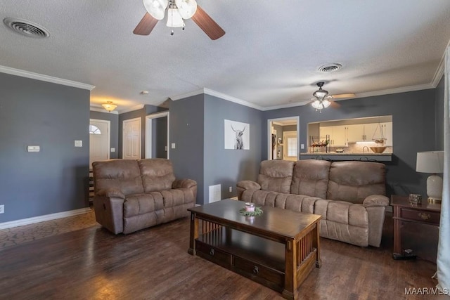 living area with baseboards, wood finished floors, visible vents, and a textured ceiling