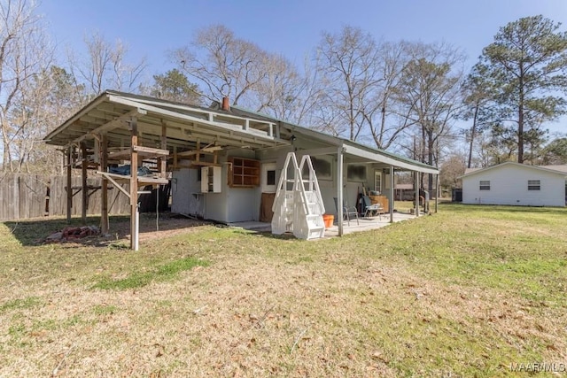 back of property with a patio area, a lawn, and a chimney