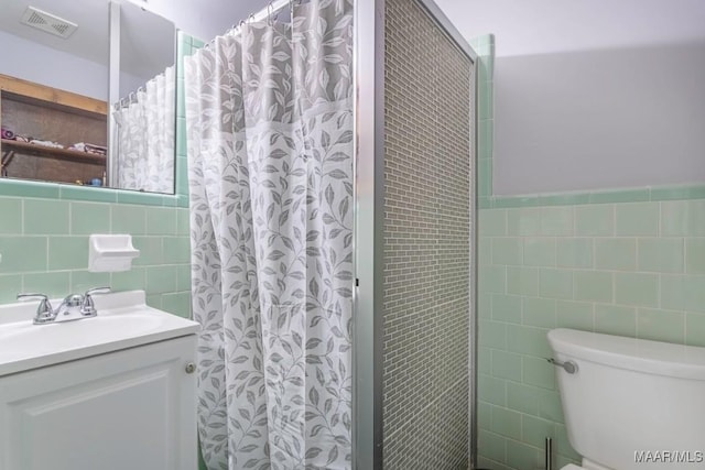 full bath with toilet, tile walls, a shower with curtain, and visible vents