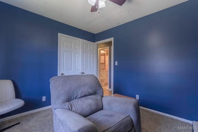 sitting room featuring carpet, baseboards, and ceiling fan