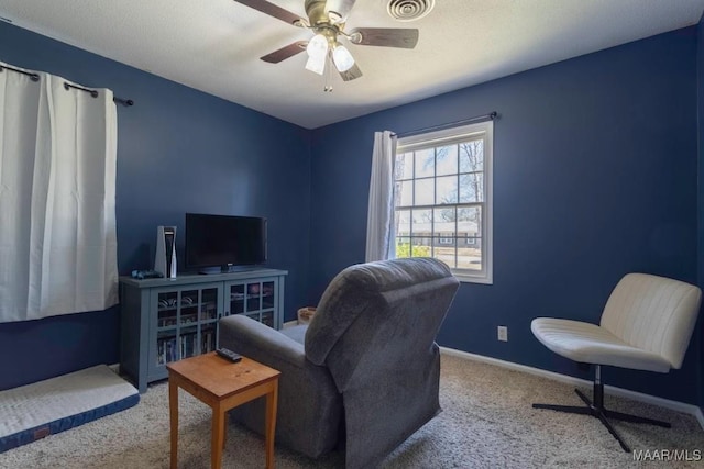 living area featuring visible vents, carpet floors, baseboards, and ceiling fan