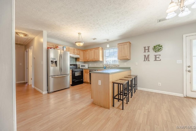 kitchen with black electric range oven, light brown cabinetry, stainless steel refrigerator with ice dispenser, light wood finished floors, and white microwave