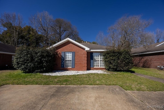 single story home with a front lawn and brick siding