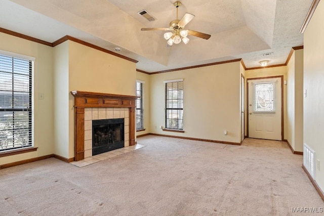 unfurnished living room featuring a tray ceiling, visible vents, ceiling fan, and carpet flooring