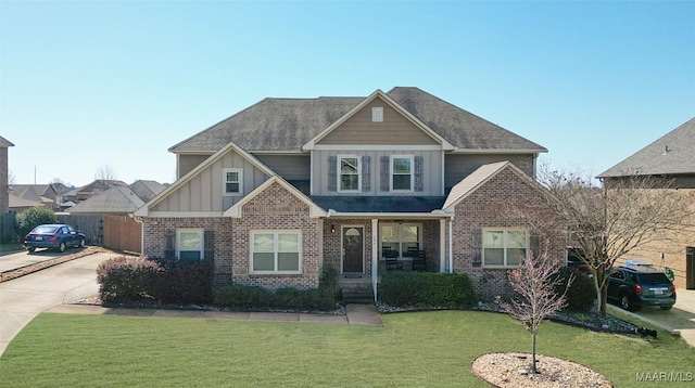 craftsman inspired home with board and batten siding, a front lawn, brick siding, and a shingled roof