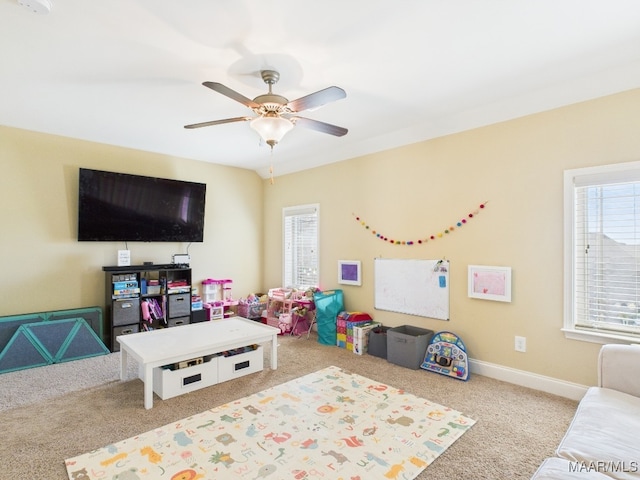 rec room featuring baseboards, a healthy amount of sunlight, ceiling fan, and carpet flooring