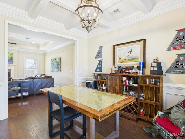 dining room with visible vents, ornamental molding, hardwood / wood-style flooring, an inviting chandelier, and a fireplace