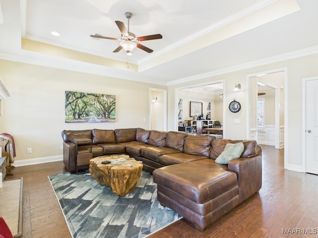 living room featuring crown molding, a tray ceiling, and wood finished floors