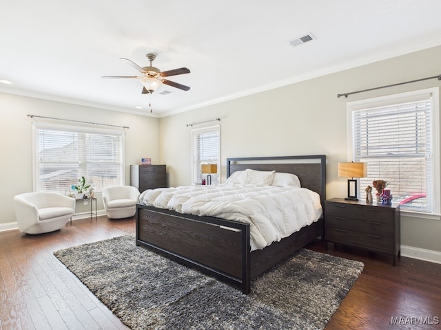 bedroom with baseboards, multiple windows, and wood finished floors