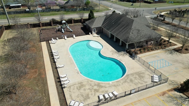 community pool with a patio area and fence