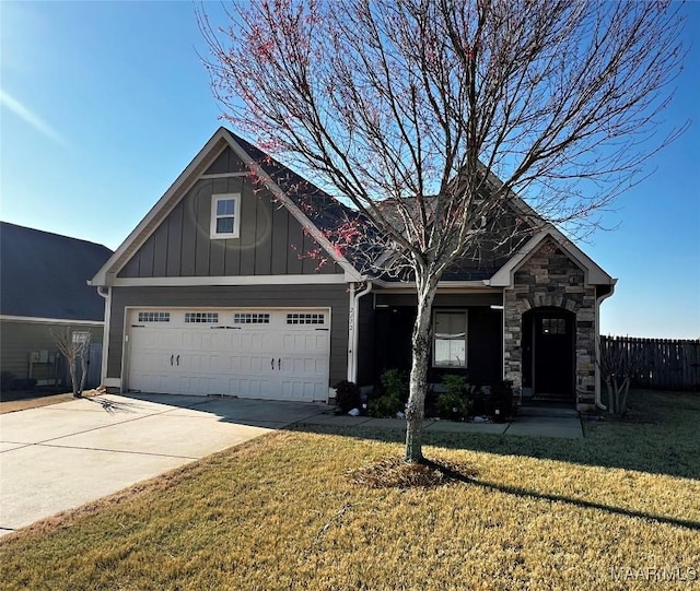 craftsman house with fence, driveway, a front lawn, stone siding, and board and batten siding