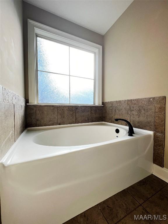 full bath featuring tile patterned floors and a bath