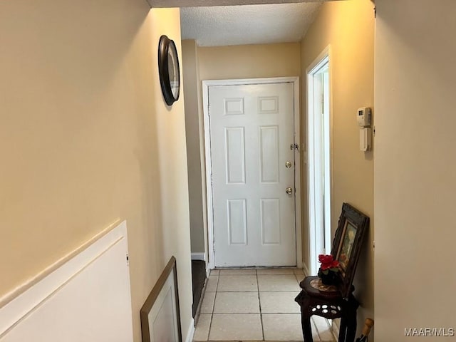 entryway with light tile patterned floors and a textured ceiling