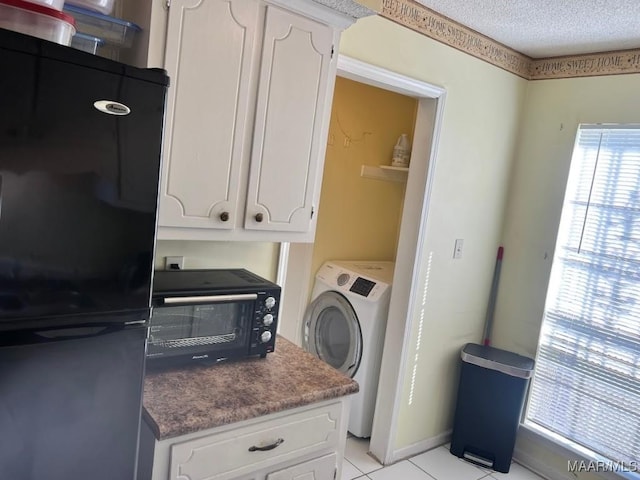 washroom featuring a textured ceiling, a toaster, light tile patterned floors, washer / dryer, and laundry area