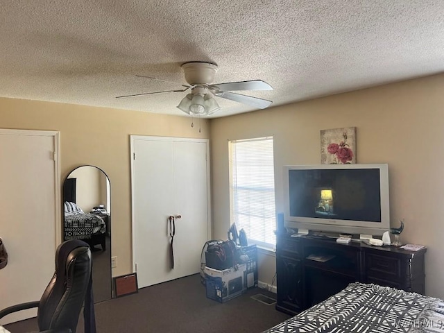 bedroom with a closet, a textured ceiling, and a ceiling fan