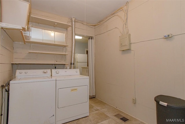 laundry room featuring washing machine and clothes dryer, visible vents, electric panel, laundry area, and light tile patterned flooring