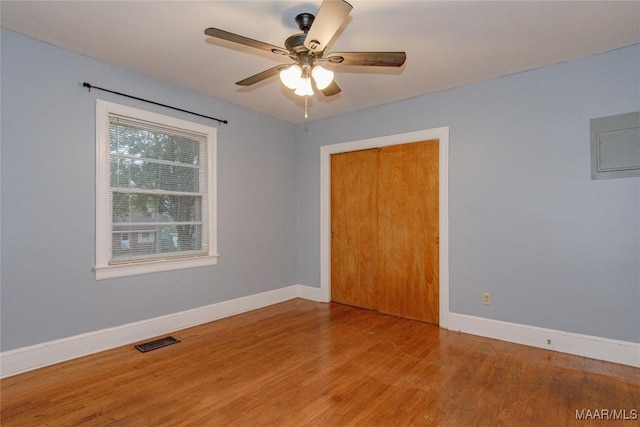 spare room featuring visible vents, a ceiling fan, baseboards, and wood finished floors