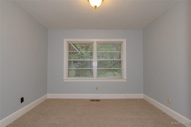 empty room featuring visible vents, baseboards, and light carpet