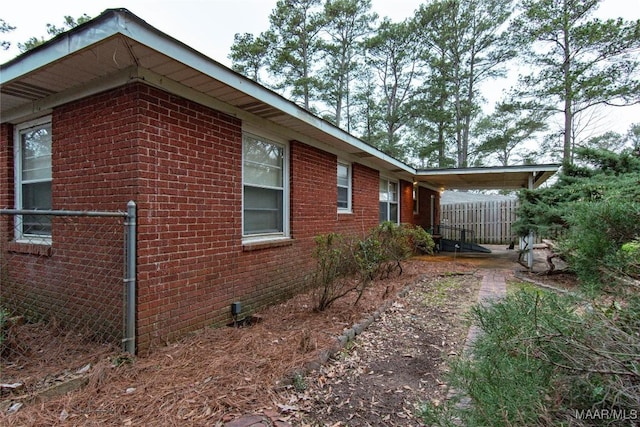 view of home's exterior with brick siding and fence