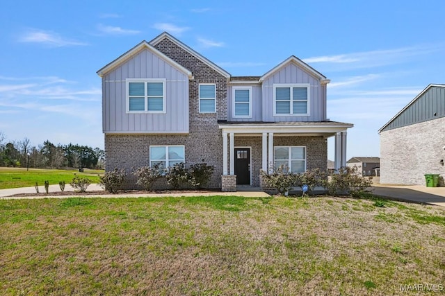 craftsman house with a front lawn, covered porch, brick siding, and board and batten siding