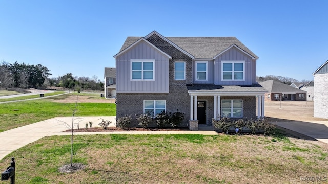 craftsman inspired home featuring brick siding, board and batten siding, concrete driveway, and a front yard