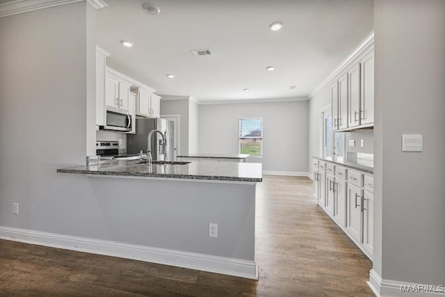 5619 Wyatt Ct, Montgomery, AL 36116 - kitchen with dark stone countertops, stainless steel appliances, visible vents, and a peninsula