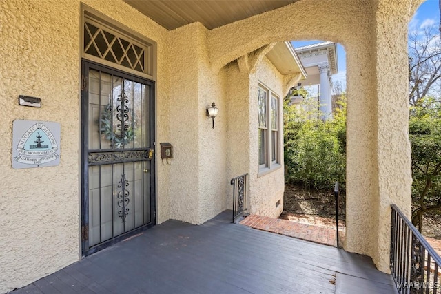 doorway to property featuring stucco siding