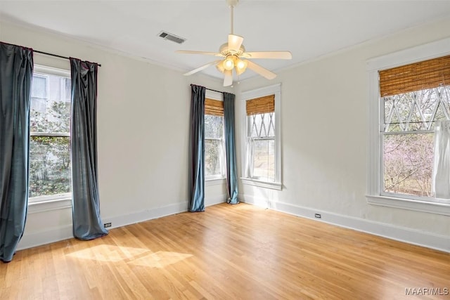 unfurnished room featuring light wood-type flooring, visible vents, baseboards, and crown molding