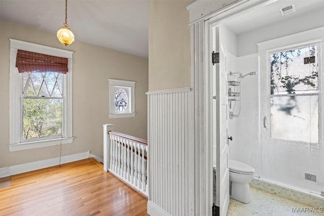 full bath with visible vents, baseboards, walk in shower, toilet, and wood finished floors