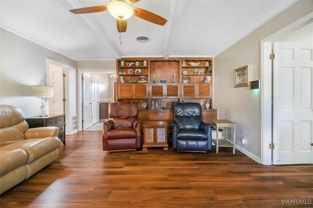 living area featuring wood finished floors, visible vents, ceiling fan, crown molding, and beamed ceiling