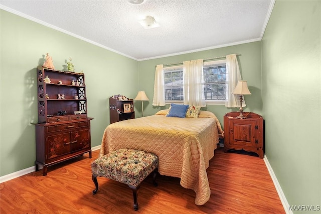 bedroom with baseboards, a textured ceiling, wood finished floors, and ornamental molding