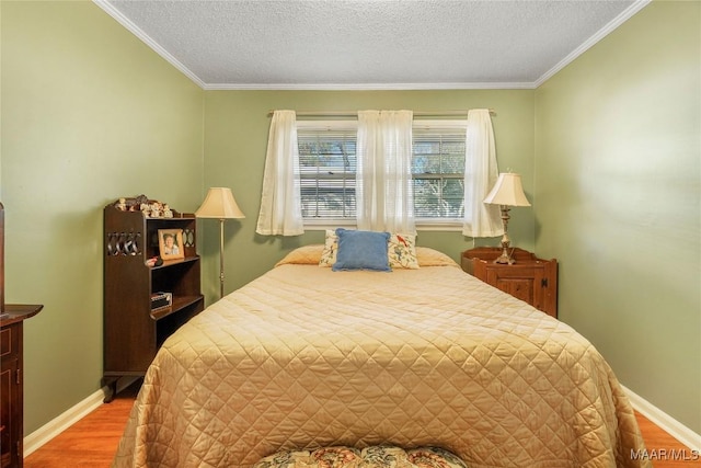 bedroom with baseboards, a textured ceiling, light wood-style flooring, and crown molding