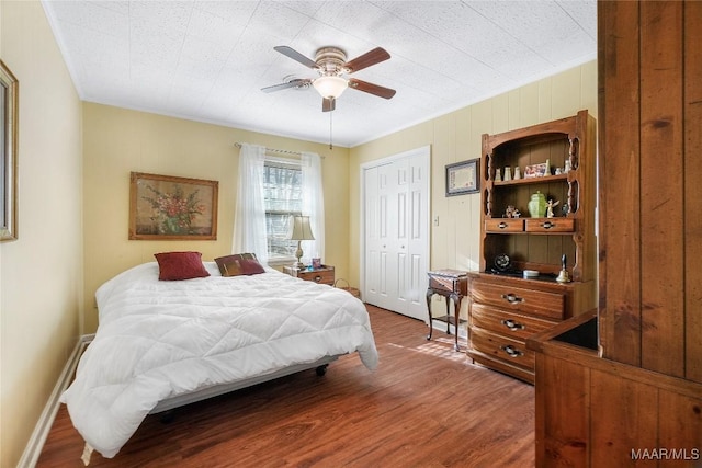 bedroom with ceiling fan, baseboards, and wood finished floors