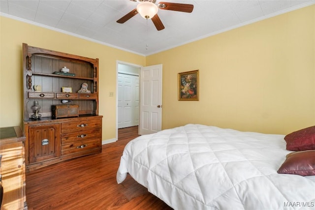 bedroom with baseboards, a ceiling fan, ornamental molding, and dark wood-style flooring