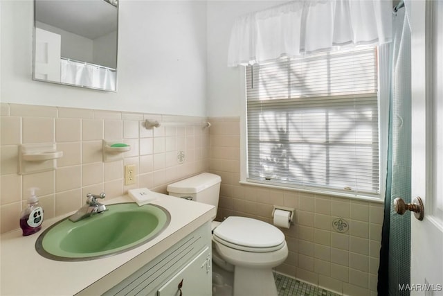 full bath featuring tile walls, toilet, and vanity