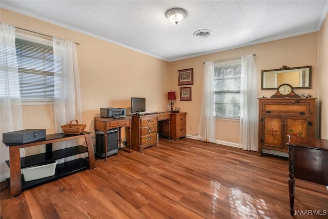 office space with visible vents, wood finished floors, and crown molding