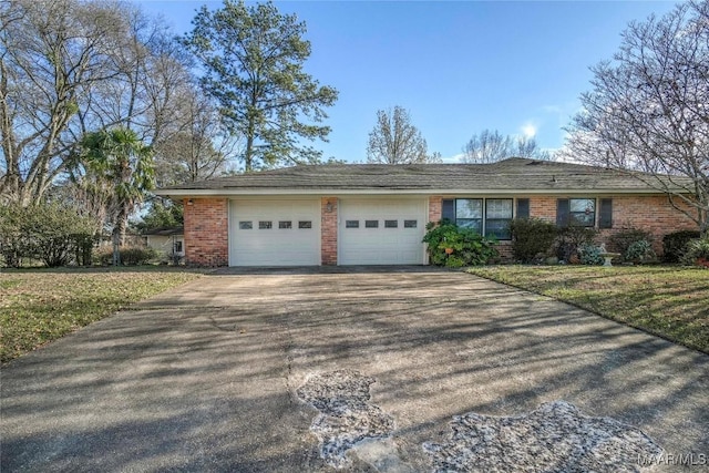 single story home with brick siding, an attached garage, driveway, and a front lawn