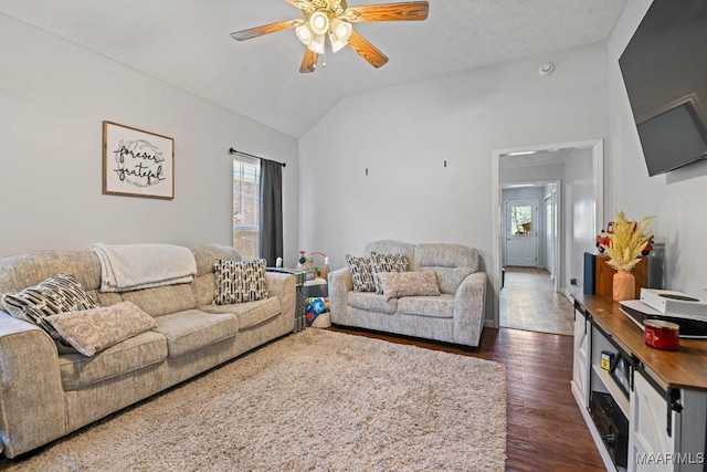 living room with lofted ceiling, dark wood-type flooring, and a ceiling fan