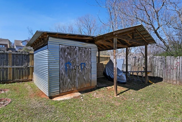 view of shed featuring a carport and a fenced backyard