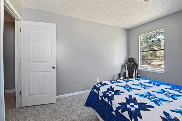 carpeted bedroom with baseboards and a textured ceiling