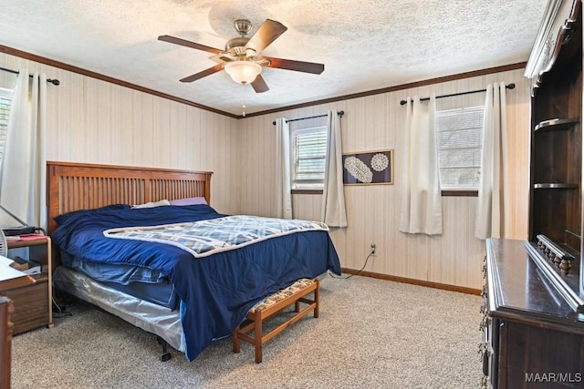 carpeted bedroom featuring baseboards, a textured ceiling, ceiling fan, and crown molding