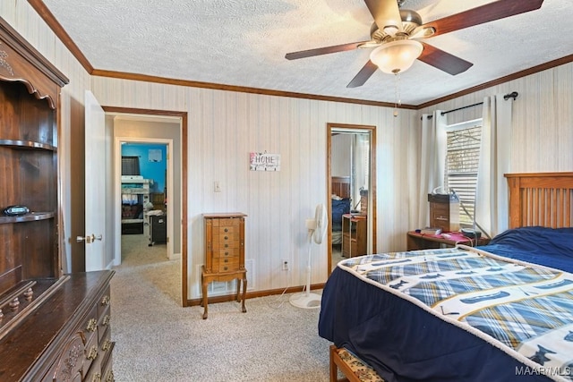 bedroom with baseboards, a textured ceiling, ornamental molding, and carpet flooring