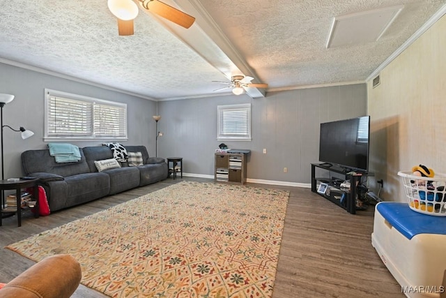 living area featuring a wealth of natural light, wood finished floors, a ceiling fan, and ornamental molding