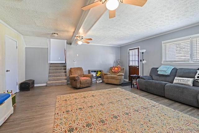 living room featuring ornamental molding, a textured ceiling, wood finished floors, ceiling fan, and stairs