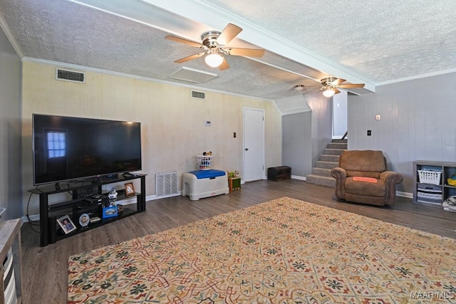 living area with visible vents, wood finished floors, and ornamental molding