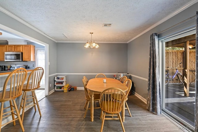 dining area with visible vents, ornamental molding, wood finished floors, baseboards, and a chandelier