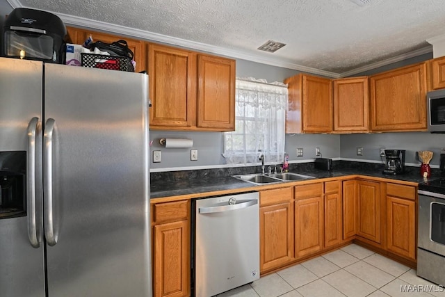kitchen with dark countertops, a sink, appliances with stainless steel finishes, a textured ceiling, and crown molding